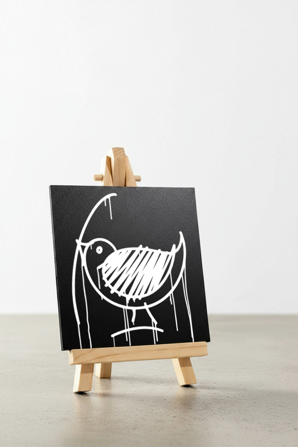 Designspiegel Mini mit Ulmer-Spatz-Motiv in schräger Ansicht auf Holzstaffelei, hochwertiges Detailfoto im Urban-Art-Stil.