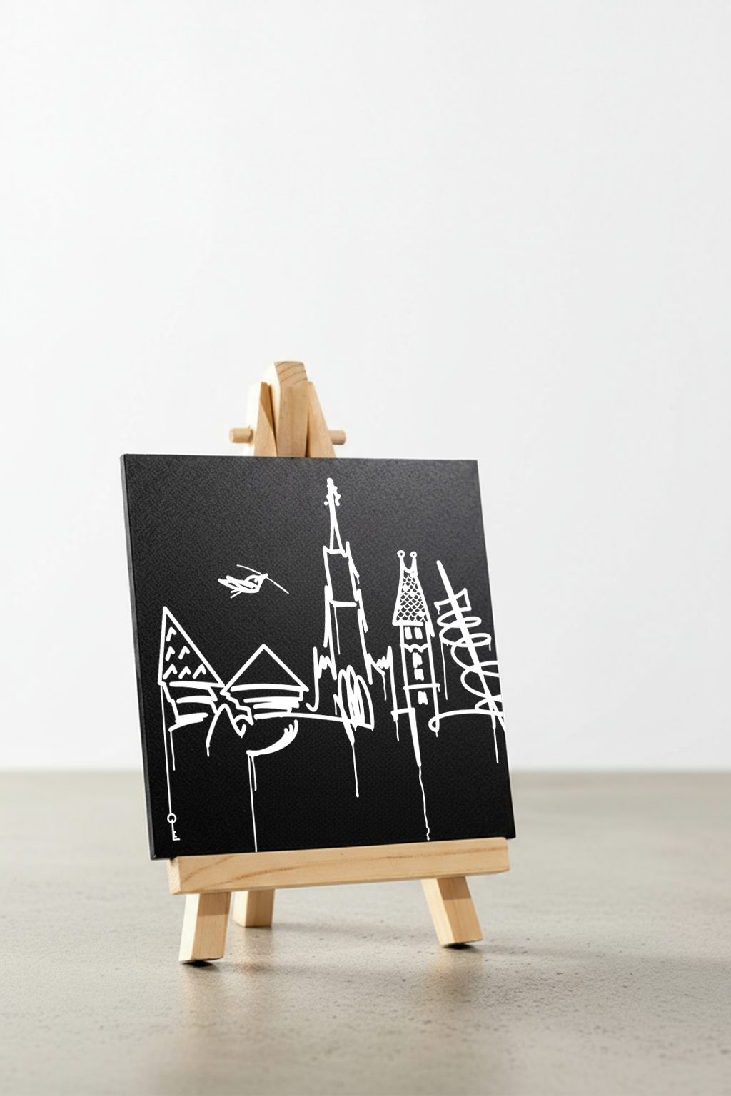 Designspiegel Mini mit Ulm Skyline, schräg fotografiert auf kleiner Holzstaffelei, minimalistische Schwarz-Weiß-Optik.