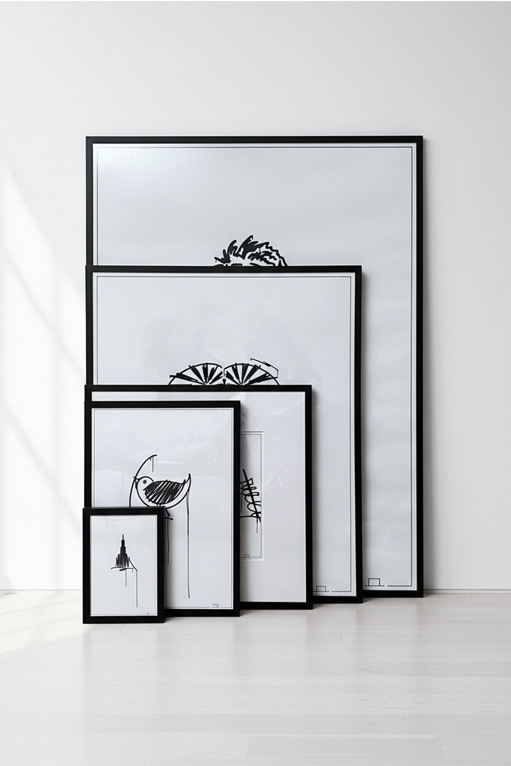 Mehrere Urban-Art Kunstdrucke in verschiedenen Größen in schwarzen Rahmen vor heller Wand, als Größenvergleich dekorativ angeordnet.