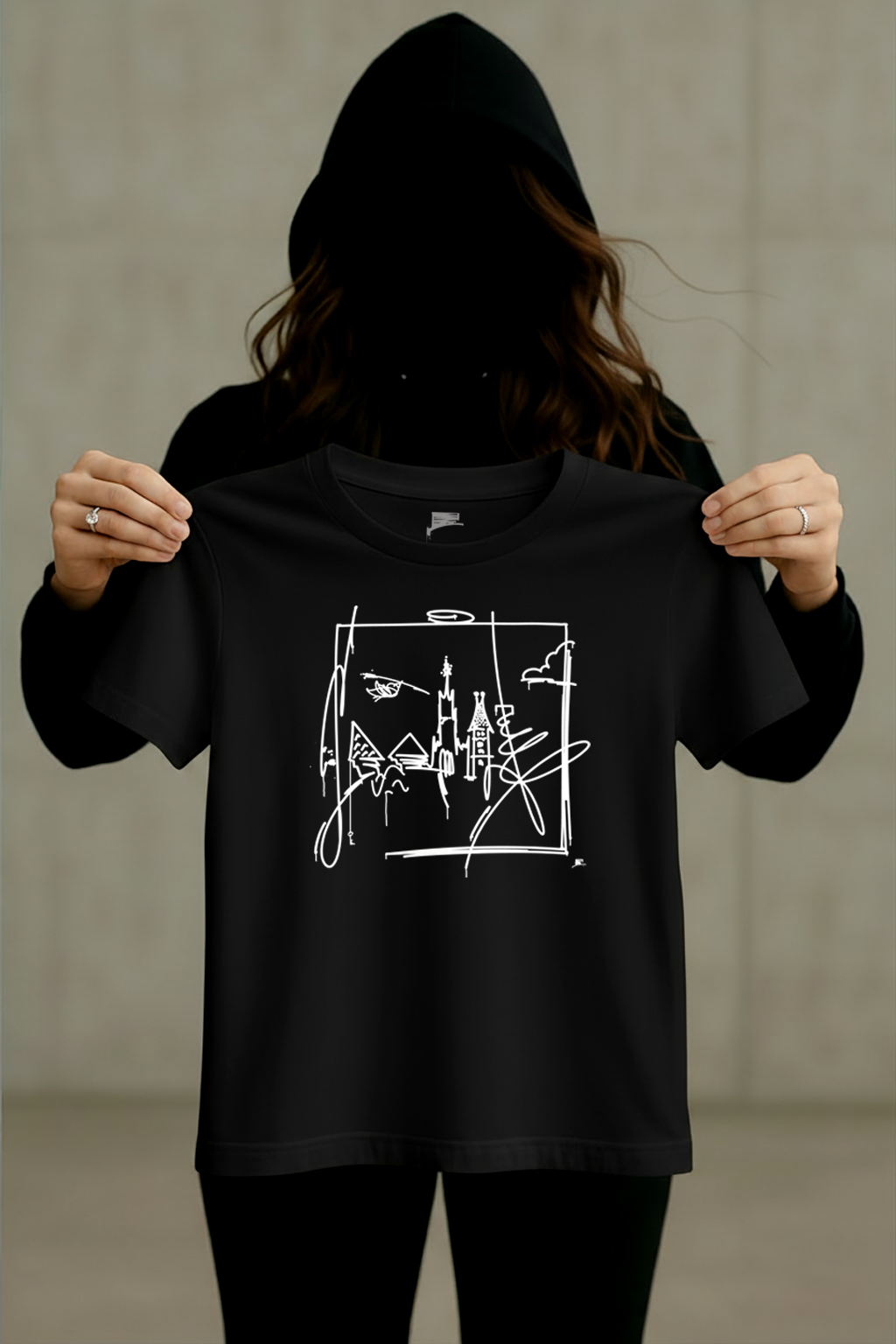 Schwarzes Ulm-T-Shirt mit weißem Linienmotiv wird von einer Person im schwarzen Hoodie präsentiert.