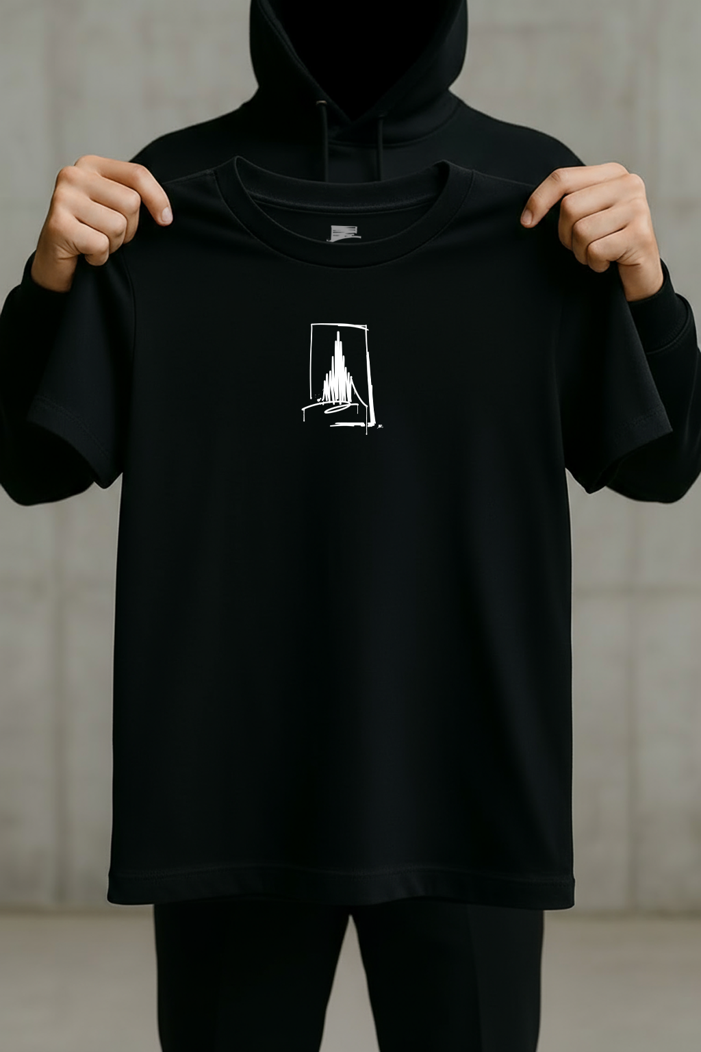 Schwarzes Urban-Art T-Shirt mit weißem Münster-Line-Art-Print, von einer schwarz gekleideten Person vor neutralem Hintergrund gehalten.